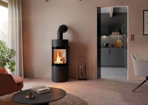 En svart fristående kamin i ett vardagsrum